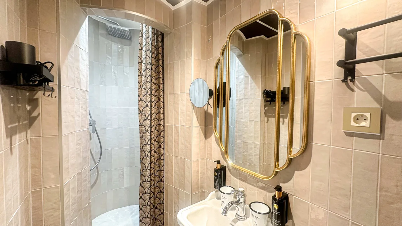 Salle de bain Classique - miroir doré Art Déco, rideau éventail, carrelage beige, hôtel Montmartre